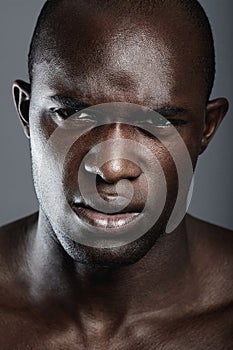 Portrait , serious and black man with skincare, cosmetics and dermatology against a grey studio background. Face, male