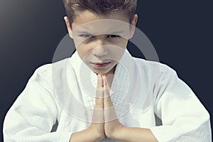 Portrait of a serious boy in a kimono greeting his opponent