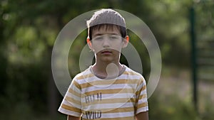 Portrait of a serious boy looking at the camera on nature