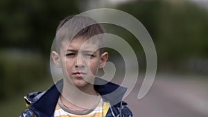 Portrait of a serious boy with a tence glance looking at the camera, close-up heavy face