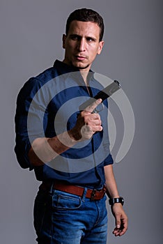 Portrait of serious businessman holding gun while thinking