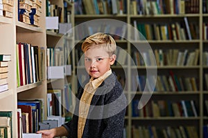 portrait of serious caucasian kid boy in library