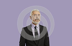 Portrait of serious and confident senior businessman isolated on pastel purple background.