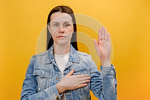 Portrait of serious conscious young woman holding hand on chest and raising another swearing, trust and honest, patriotism,