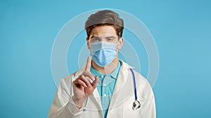 Portrait of serious doctor in professional medical white coat showing rejecting gesture disapproving with no finger sign