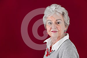 Portrait of serious elderly woman in red and gray