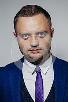 Portrait of serious fashionable handsome man in blue suit looking at camera