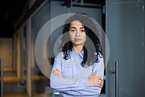 Portrait of serious female boss inside business company office, businesswoman crossed arms looking concentrated at