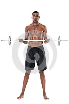 Portrait of a serious fit young man lifting barbell