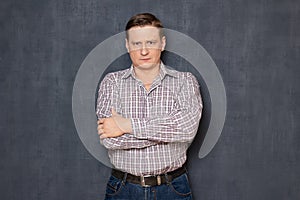 Portrait of serious focused man holding arms crossed on chest