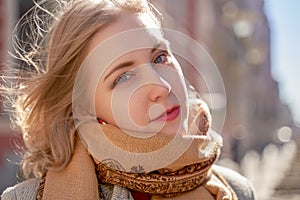 Portrait of serious girl in the autumn on background of City. Fashionable women in scarf and red lipstick looking at camera