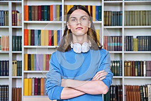 Portrait of serious guy student looking at camera in library