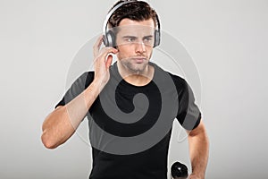 Portrait of a serious handsome sportsman listening to music