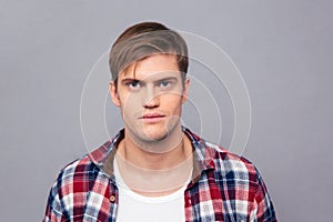 Portrait of serious handsome young man in checkered shirt