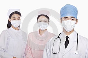 Portrait of serious healthcare workers with surgical masks, studio shot