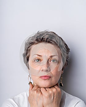 Portrait of a serious looking woman of 40-50 with graying hair and no make up