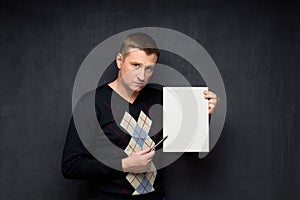 Portrait of serious man holding blank paper sheet