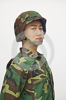 Portrait of serious man in military uniform and helmet, studio shot