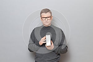 Portrait of serious mature man with glasses holding big book in hands