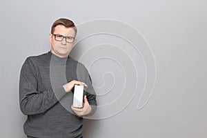 Portrait of serious mature man with glasses holding big book in hands