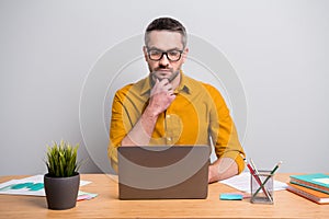 Portrait of serious minded man sit desk table work home laptop read colleagues project feel pensive analyze work home