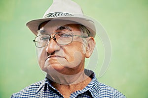 Portrait of serious old man with hat looking at camera