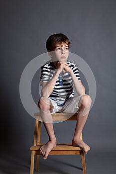 Portrait of serious pensive sad teenager on chair