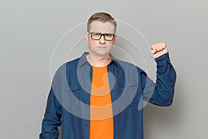 Portrait of serious rebellious mature man raising clenched fist up