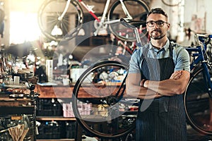 Portrait, serious and repair man in bicycle shop with arms crossed in workshop. Face, bike mechanic and confident male