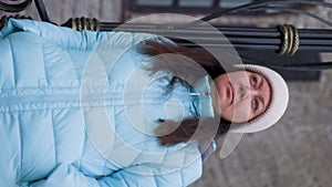 Portrait serious sad pensive middle aged woman in blue jacket walking on street. Depressive brunette female in hat