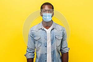 Portrait of serious self-assertive handsome man with medical mask with rolled up sleeves looking smart and professional,