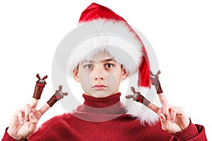 Portrait of serious teen boy in Santa hat with deer toy up isolated on white