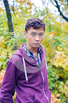 Portrait of a serious teenage boy in an autumn forest