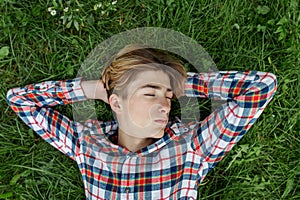 Portrait of serious teenager who lies in grass and rests. Gen Z. Identity development