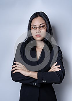 Portrait of serious thoughtful businesswoman in black confident suit, isolated over gray background