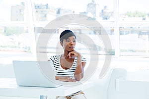 Portrait of a serious thoughtful businesswoman using laptop in office