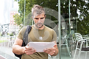 Portrait of serious urban man lwith tablet computer in the street.