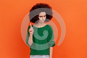 Portrait of serious woman with Afro hairstyle wearing green casual style sweater looking at camera