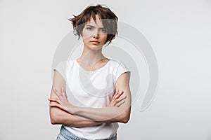 Portrait of serious woman with short brown hair in basic t-shirt frowning and looking at camera