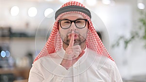 Portrait of Serious Young Arab Man Putting Finger on Lips