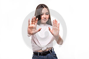 Portrait of serious young asian woman standing with outstretched hand showing stop gesture isolated over white background