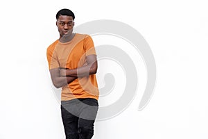 Serious young black man in t shirt posing against isolated white background with arms crossed