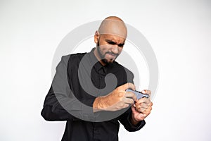 Portrait of serious young man playing mobile phone games