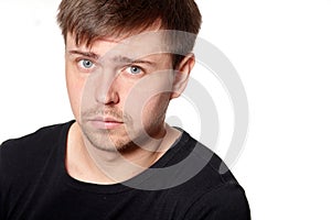 Portrait of serious young man, questioning expression,horizontal on white background with space for text