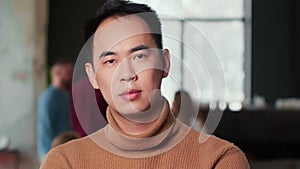 Portrait of serious young professional confident Asian IT coach businessman looking at camera at modern trendy office.