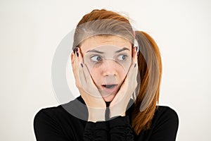 Portrait of serious young woman holding her hands to face thinking concentrated about something