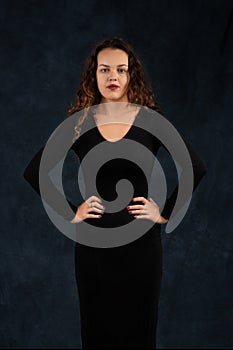 Portrait of a serious young woman with long curly hair wearing