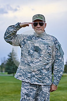 Portrait of severe caucasian soldier is saluting.