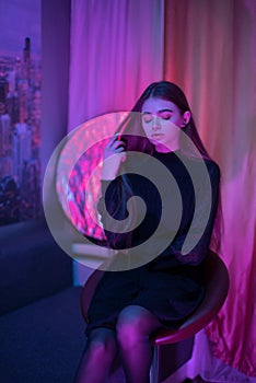 Portrait of sexual brunette lady in glitter jacket without panties posing on camera sits on chair