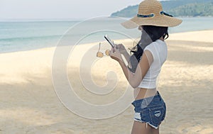 Portrait of sexy girl relax on the beach and using smartphone for chatting. Relaxation Concept